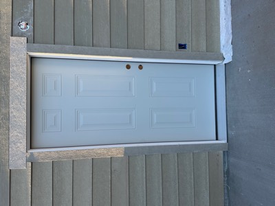 Newly installed white six-panel exterior door with new trim